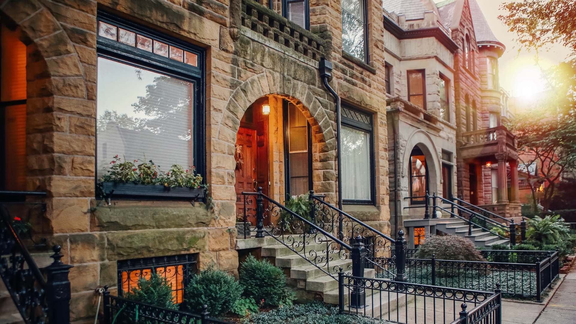 An image of Victorian Chicago row homes with gated front yards and plants