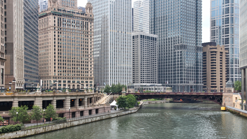 Image of the Chicago Loop train and Chicago Riverwalk with skyscrapers in the background during the day