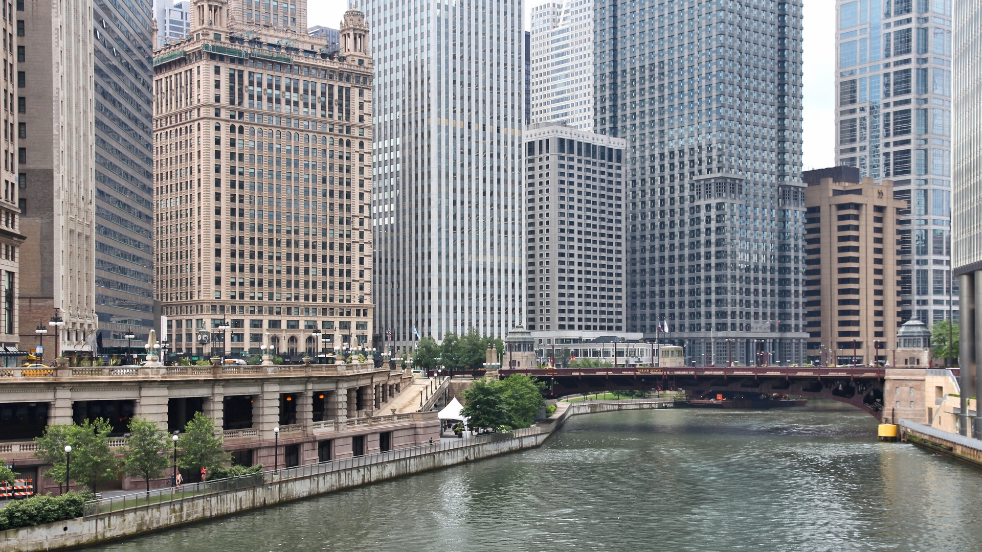 Image of the Chicago Loop train and Chicago Riverwalk with skyscrapers in the background during the day