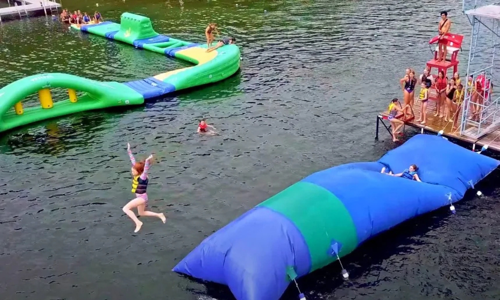 Sky-view image of children playing on bouncy water floats at Lake Arlington in Arlington Heights, IL