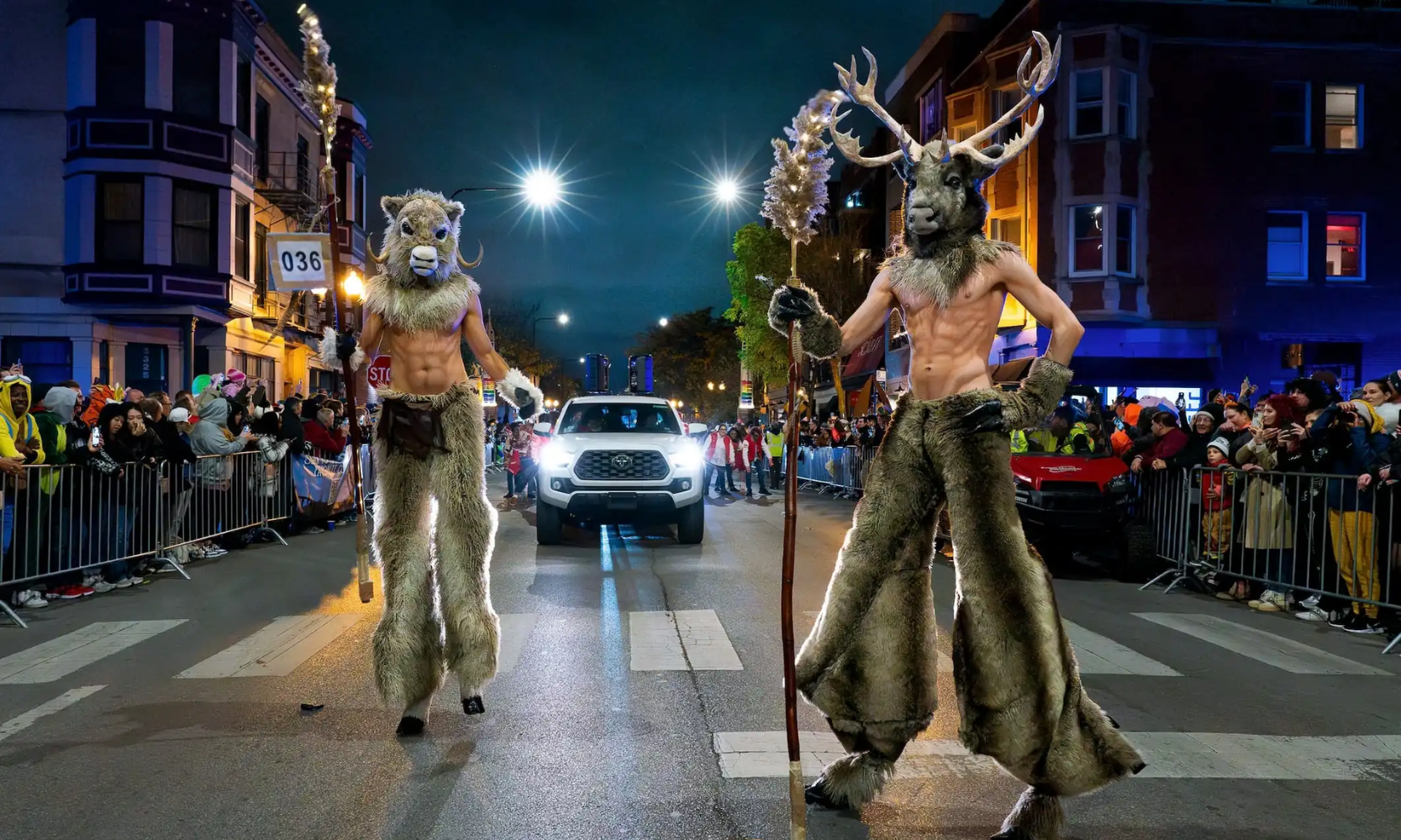 Image of two people dressed up as giant minotaurs in the streets of the Haunted Halsted Halloween Parade