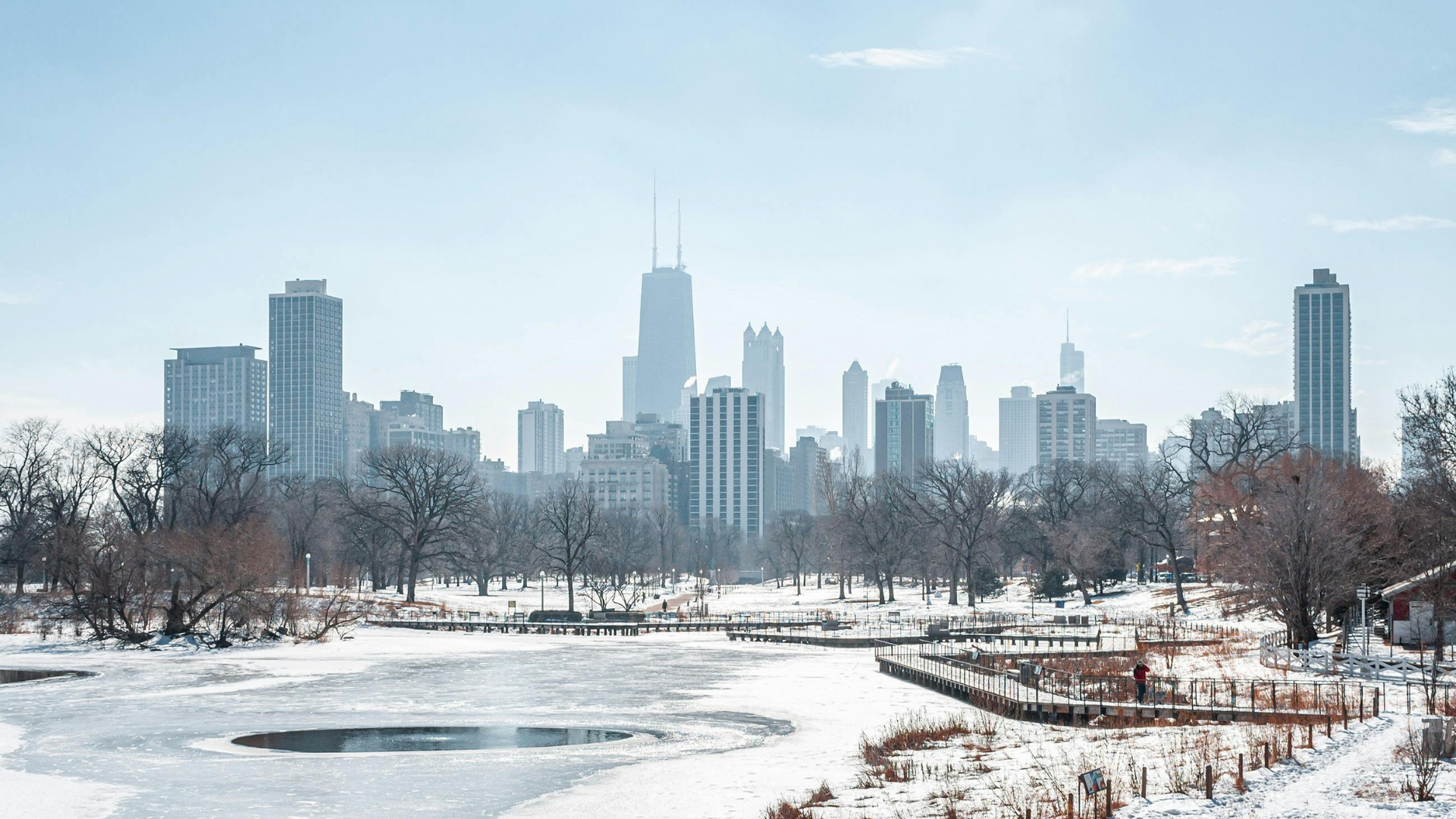 Wideshot image of the Chicago skyline during winter with snow covered paths and water