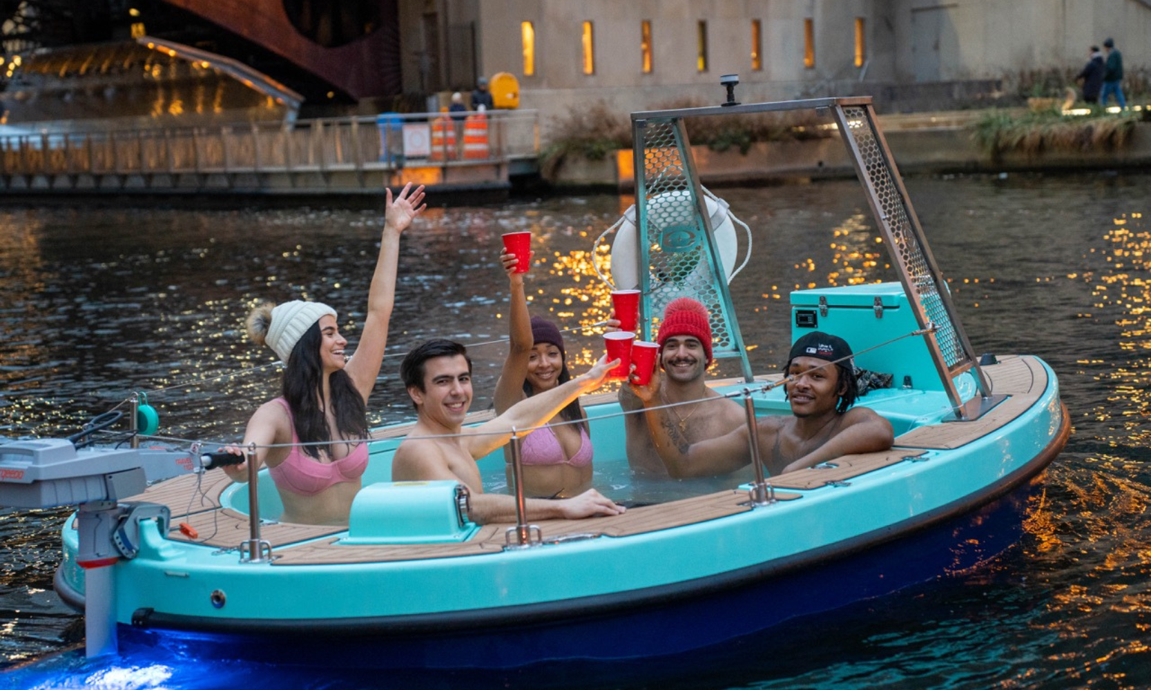 A group of young people drinking from red cups on a hot tub boat on the Chicago River