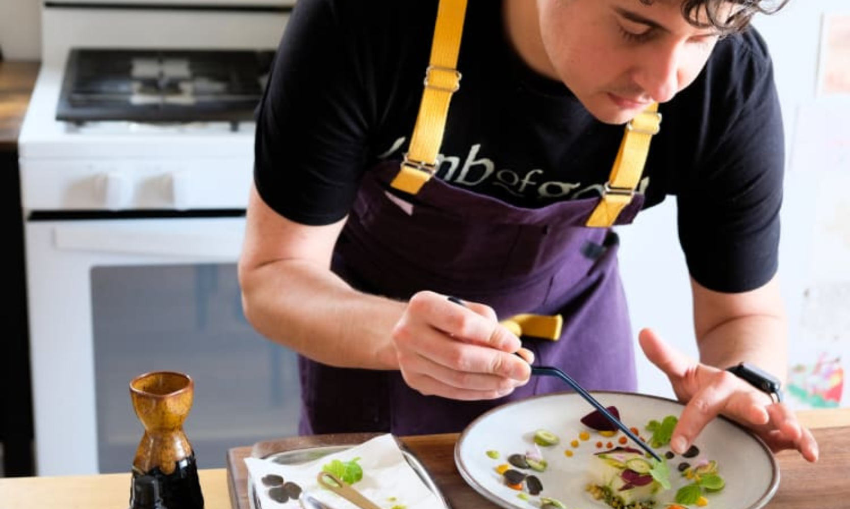 Closeup image of chef Donald Young preparing a dish at Duck Sel in Chicago