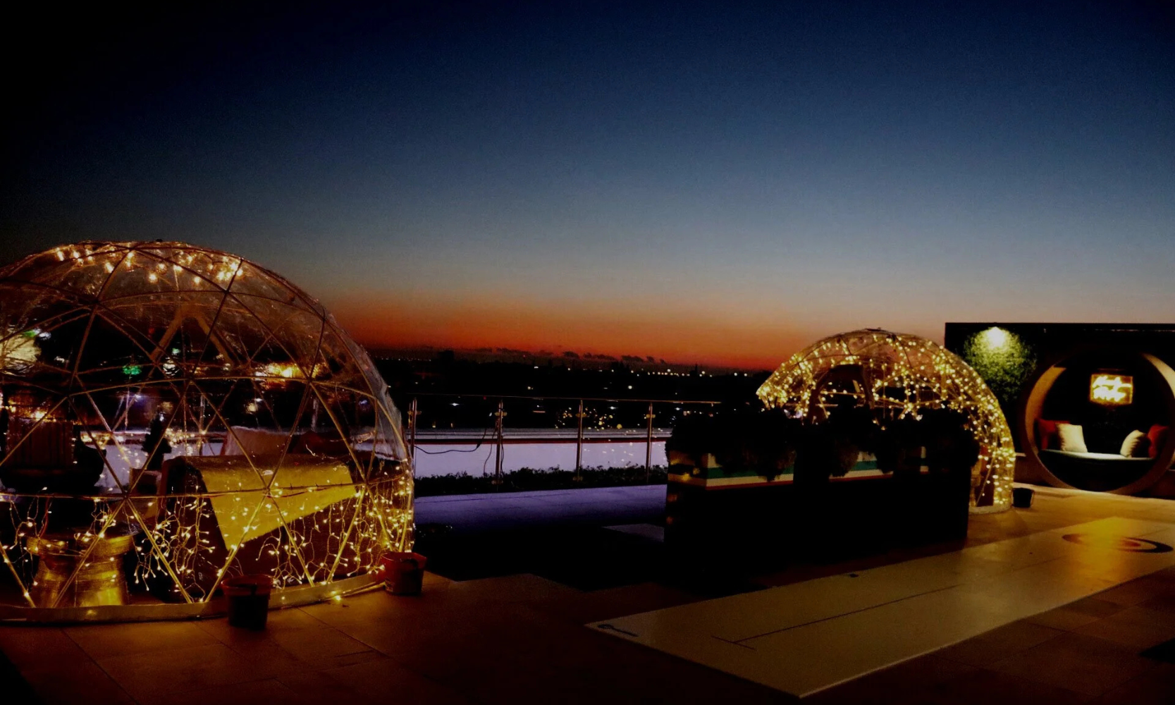 Image of Kennedy Rooftop's illuminating igloo seating areas at night in Chicago