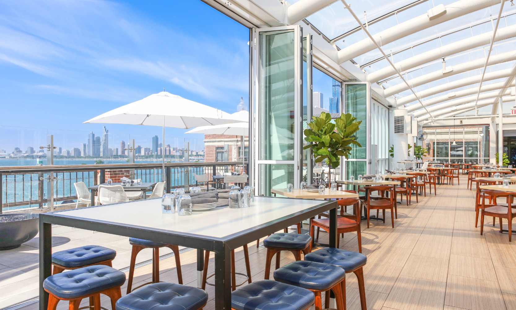 Image of Offshore Rooftop's inside and outside rooftop dining areas with the Chicago skyline in the background